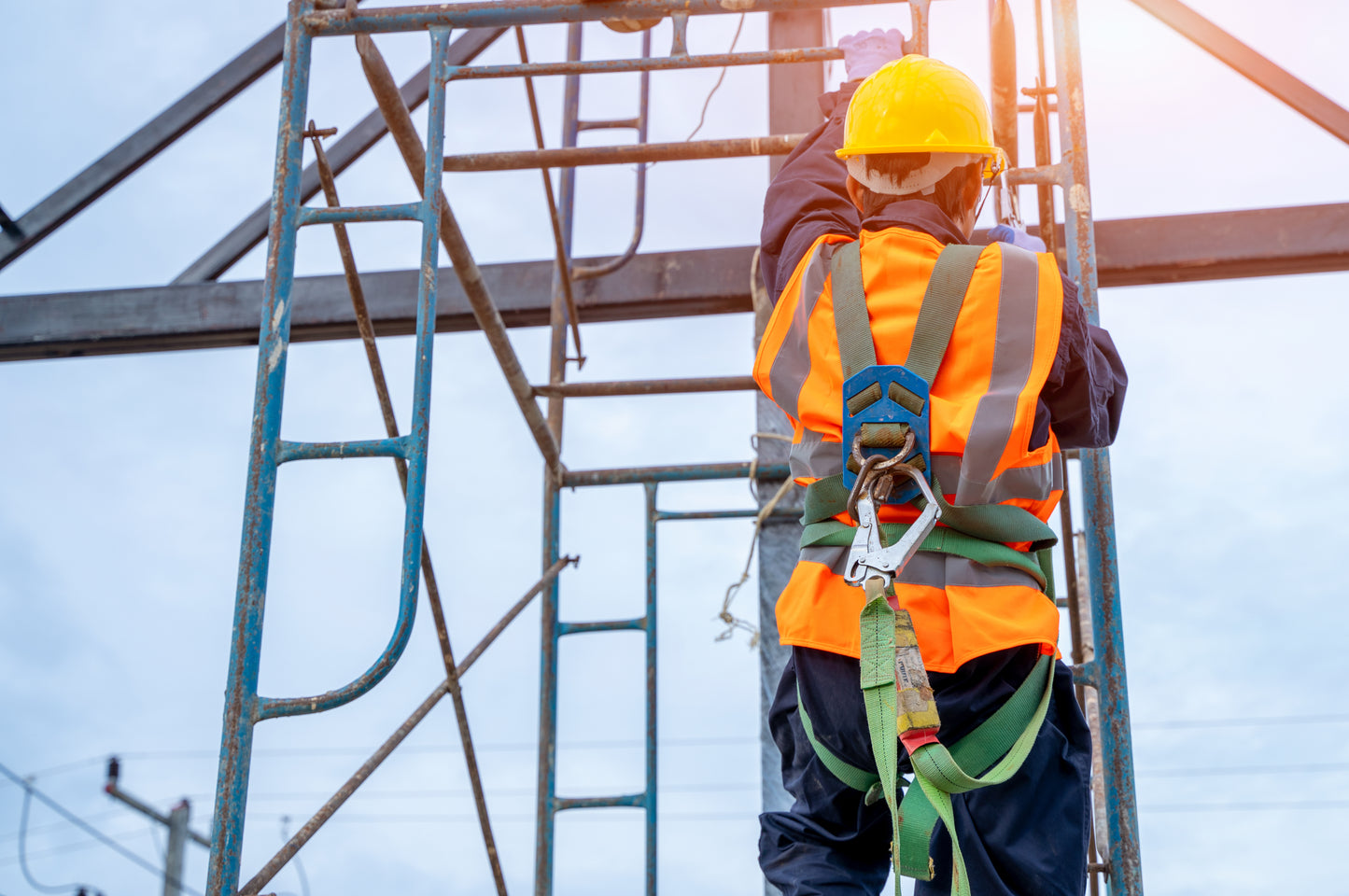 Construction worker using safety harness while working at height