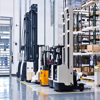 Factory workers using forklifts during OSHA-compliant operations